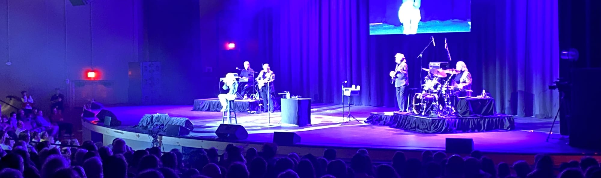 signer on stage in chair washed out by the lights South Bend
